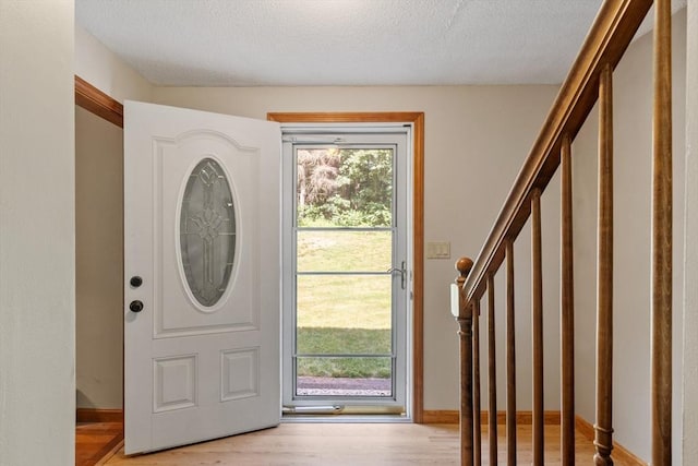 65 Martin Rd, Tewksbury, MA 01876 - entrance foyer featuring stairway, plenty of natural light, light wood finished floors, and a textured ceiling