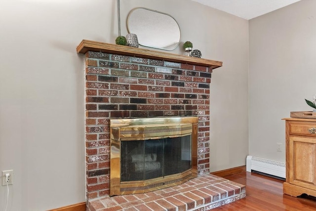 65 Martin Rd, Tewksbury, MA 01876 - detailed view of a fireplace, a baseboard heating unit, and wood finished floors
