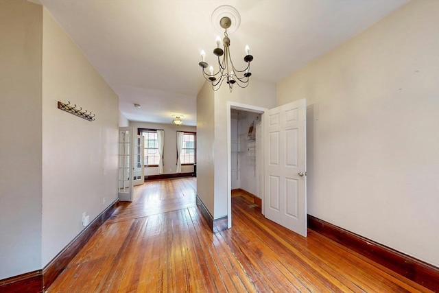70 Revere St Unit 5, Boston, MA 02114 - hall with hardwood / wood-style floors, a chandelier, and baseboards
