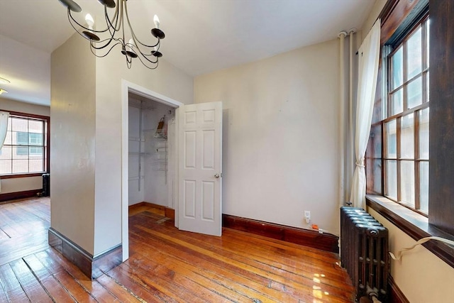 70 Revere St Unit 5, Boston, MA 02114 - unfurnished dining area with radiator heating unit, wood-type flooring, baseboards, and a chandelier