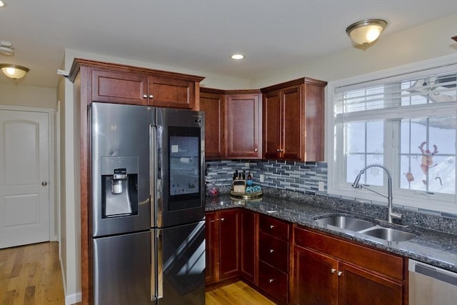 kitchen featuring reddish brown cabinets, stainless steel appliances, tasteful backsplash, and a sink