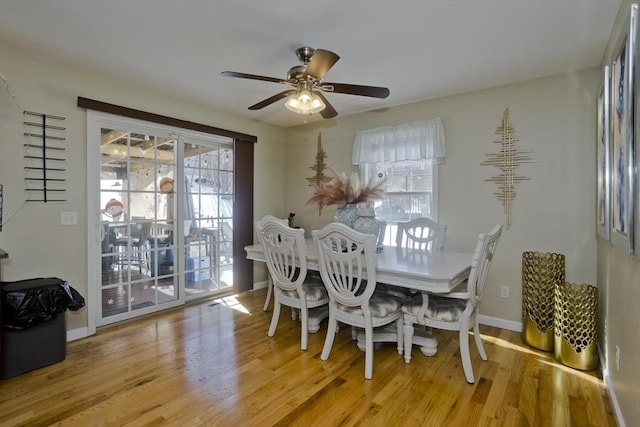 dining space with ceiling fan, light wood-style flooring, and baseboards