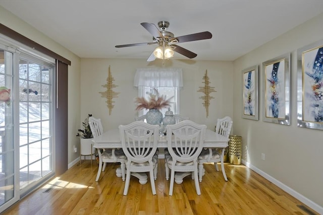 dining space featuring light wood-style flooring, baseboards, and a wealth of natural light