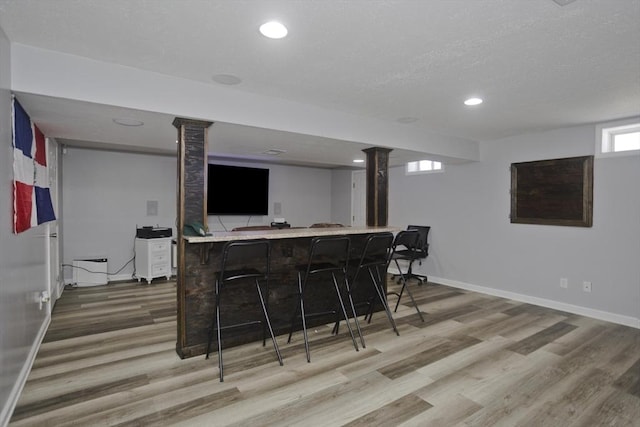 bar with recessed lighting, a textured ceiling, baseboards, and wood finished floors