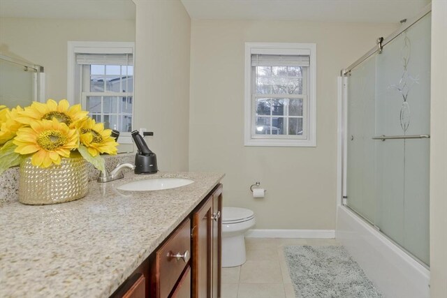 bathroom featuring tile patterned flooring, plenty of natural light, vanity, and toilet