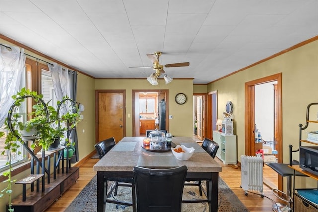 dining area with baseboards, ornamental molding, radiator heating unit, and wood finished floors