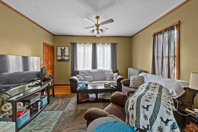 living area featuring ornamental molding, ceiling fan, baseboards, and wood finished floors