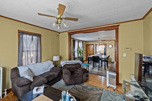 living room featuring a healthy amount of sunlight, crown molding, and wood finished floors