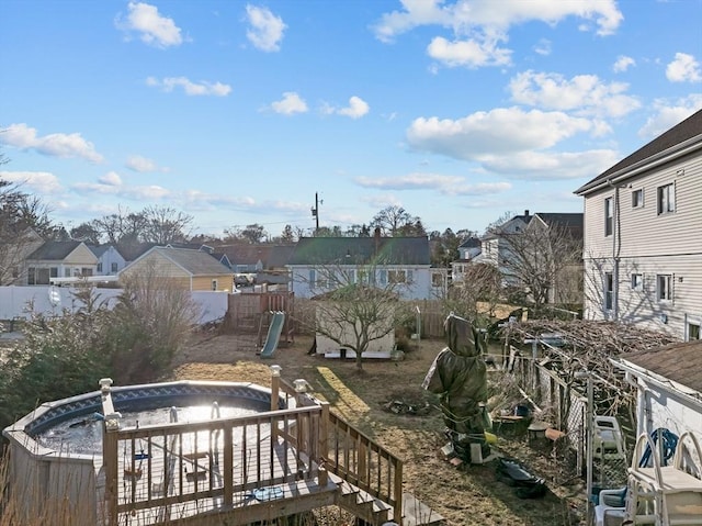 wooden deck featuring a residential view and a fenced backyard