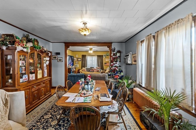 dining area featuring ornamental molding and light wood finished floors