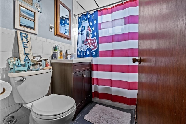 full bath featuring curtained shower, tile patterned flooring, toilet, vanity, and tile walls