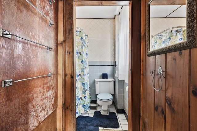 bathroom featuring tile patterned flooring, toilet, tile walls, and a shower with curtain
