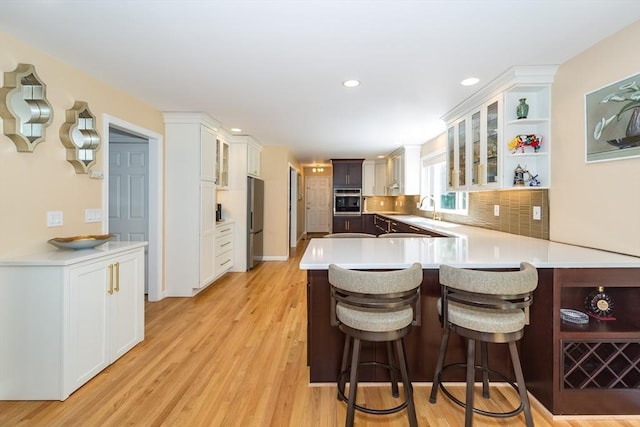 113 Sparrow Rd, Stoughton, MA 02072 - kitchen with stainless steel appliances, a peninsula, open shelves, a breakfast bar, and glass insert cabinets