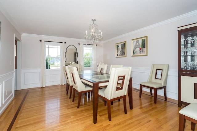 113 Sparrow Rd, Stoughton, MA 02072 - dining room with a chandelier, light wood-style flooring, crown molding, a wainscoted wall, and a decorative wall