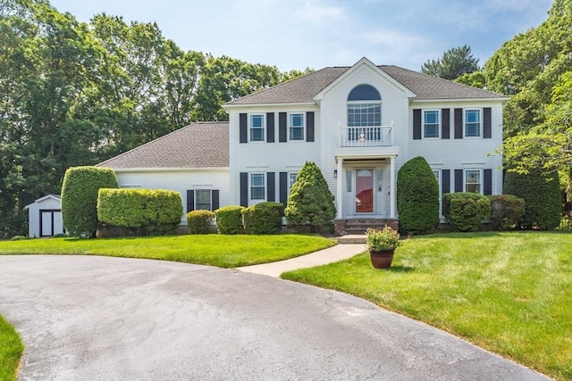 113 Sparrow Rd, Stoughton, MA 02072 - colonial-style house with a storage unit, a front lawn, a balcony, and a shingled roof