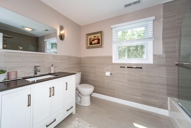 113 Sparrow Rd, Stoughton, MA 02072 - full bath with tile walls, vanity, shower / bathtub combination, a wainscoted wall, and wood finished floors