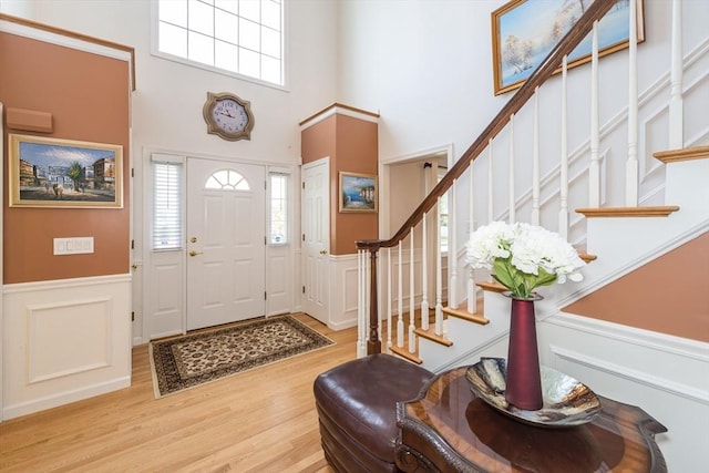 113 Sparrow Rd, Stoughton, MA 02072 - entrance foyer with a decorative wall, a wainscoted wall, wood finished floors, stairway, and plenty of natural light