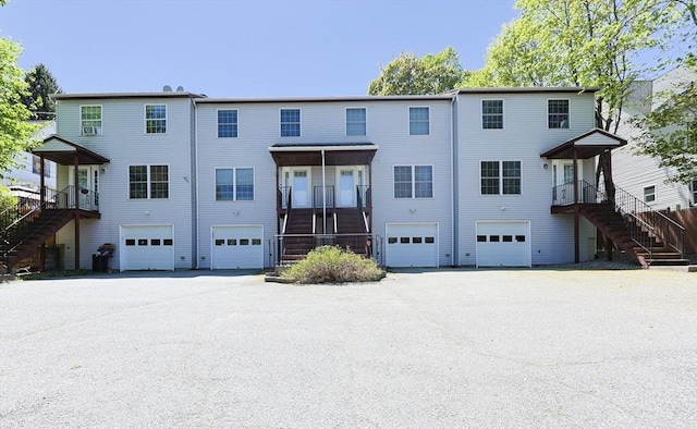 view of front facade featuring a garage, stairs, and driveway