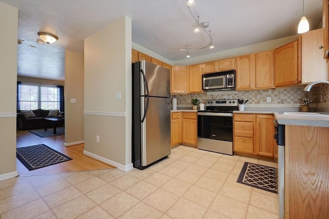 kitchen featuring light countertops, stainless steel appliances, a sink, and tasteful backsplash
