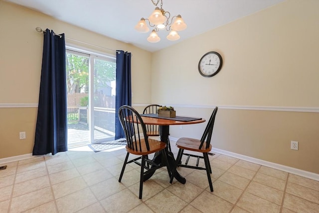 dining space featuring baseboards and a chandelier