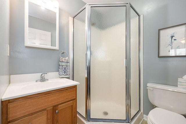 full bathroom with vanity, a shower stall, and toilet