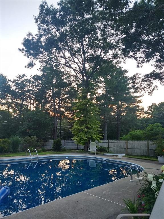 view of swimming pool featuring a diving board, a fenced in pool, a patio, and fence