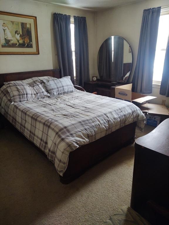 bedroom with multiple windows and carpet floors