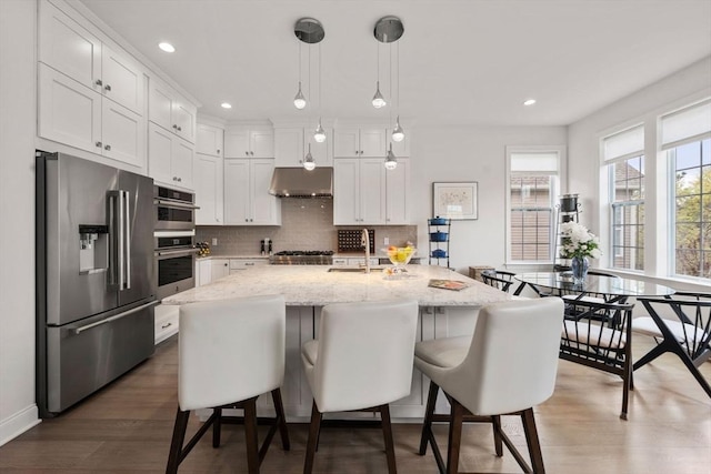 21 Snapping Bow, Plymouth, MA 02360 - kitchen featuring appliances with stainless steel finishes, extractor fan, white cabinets, decorative backsplash, and recessed lighting