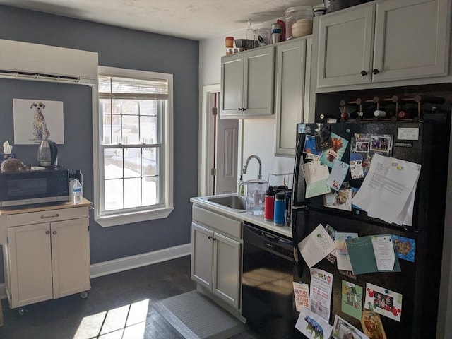 kitchen featuring light countertops, a healthy amount of sunlight, a sink, and black appliances