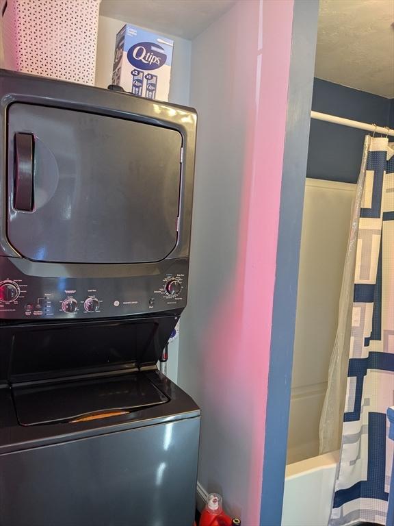 laundry room featuring stacked washer and dryer and laundry area