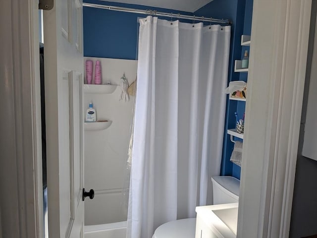 bathroom featuring a shower with shower curtain and toilet