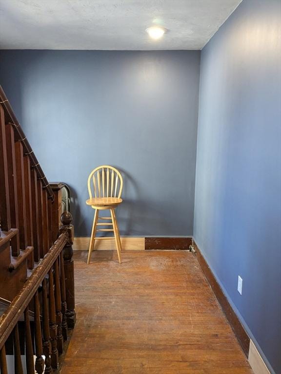 empty room featuring stairs, wood finished floors, and baseboards