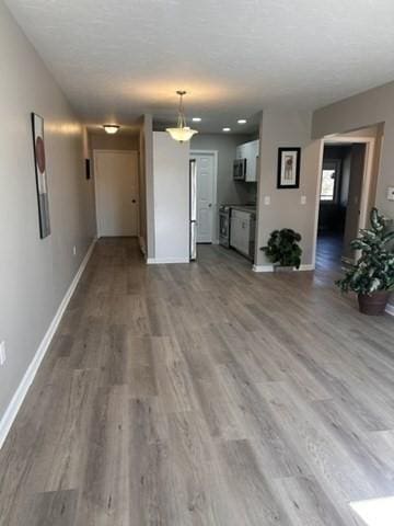 unfurnished living room with baseboards and wood finished floors