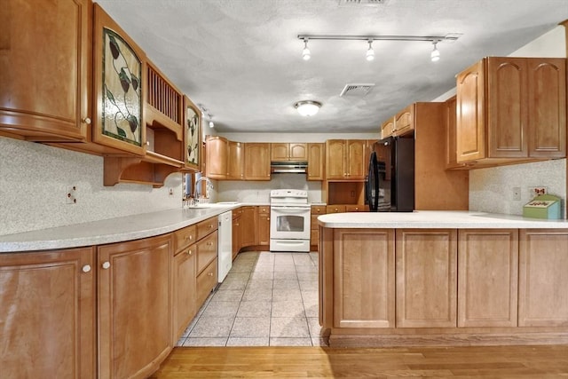 210 Plain Dr, Stoughton, MA 02072 - kitchen with white appliances, under cabinet range hood, a peninsula, and light countertops