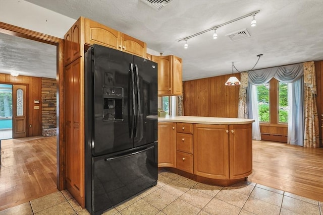 210 Plain Dr, Stoughton, MA 02072 - kitchen featuring black fridge with ice dispenser, wood walls, plenty of natural light, a peninsula, and light countertops