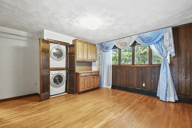 210 Plain Dr, Stoughton, MA 02072 - washroom featuring estacked washer and dryer, light wood-style floors, and a textured ceiling