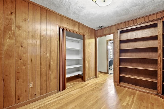 210 Plain Dr, Stoughton, MA 02072 - spare room featuring wood walls and light wood-style floors