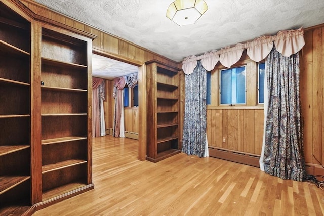 210 Plain Dr, Stoughton, MA 02072 - unfurnished bedroom featuring baseboard heating, wooden walls, wood finished floors, and a textured ceiling