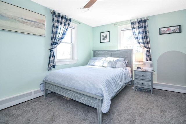 bedroom featuring carpet flooring, multiple windows, a baseboard heating unit, and visible vents