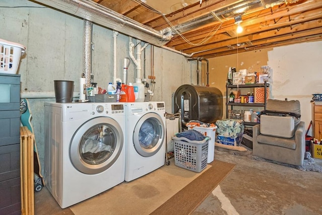 washroom with washing machine and clothes dryer, laundry area, and heating fuel