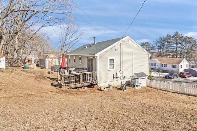 rear view of property with central air condition unit, fence, a shed, an outdoor structure, and a wooden deck