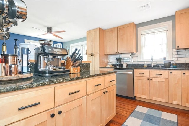 kitchen featuring stainless steel dishwasher, light brown cabinets, and a sink