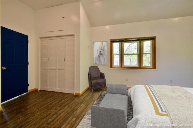 bedroom with dark wood finished floors, baseboards, lofted ceiling, and a closet