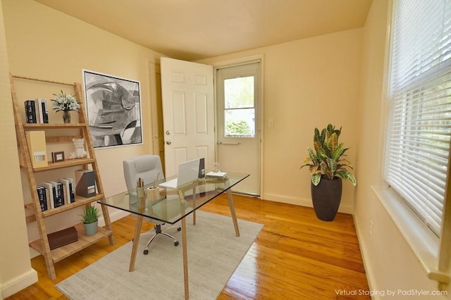 home office featuring light wood-type flooring and baseboards