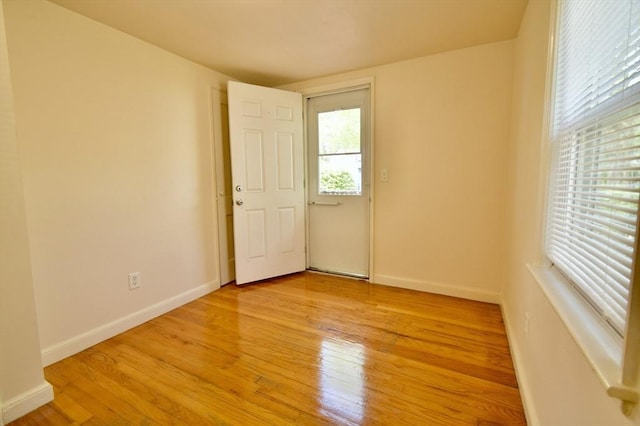unfurnished room with light wood-style floors and baseboards