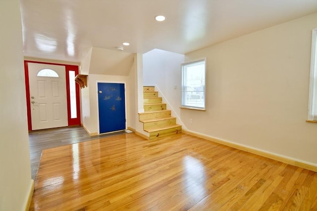 entryway featuring wood finished floors, stairs, baseboards, and recessed lighting