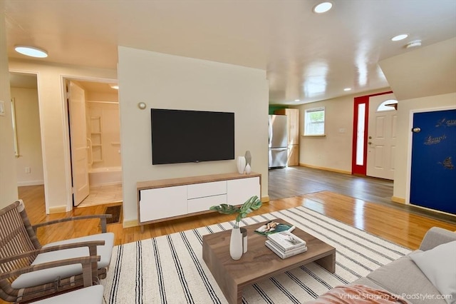 living room featuring light wood-style flooring, recessed lighting, and baseboards