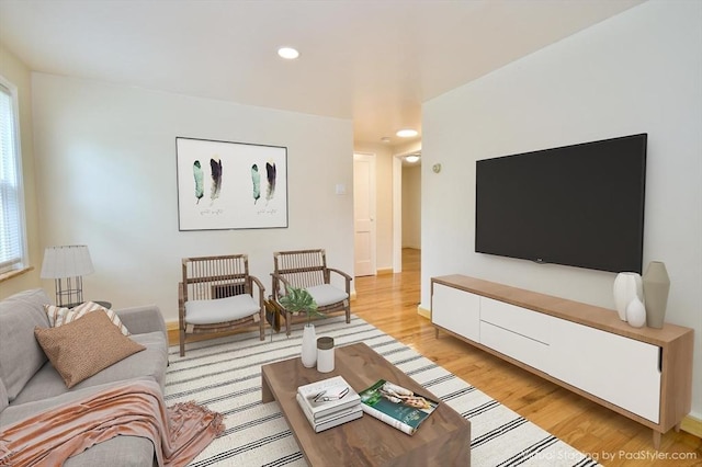 living area with recessed lighting, light wood-style flooring, plenty of natural light, and baseboards