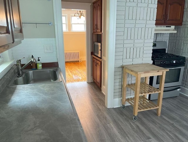 39 Barnard Rd, Worcester, MA 01605 - kitchen featuring stainless steel gas range, premium range hood, radiator, dark wood-style floors, and decorative backsplash