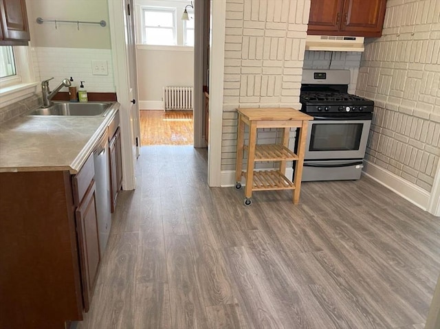 39 Barnard Rd, Worcester, MA 01605 - kitchen with appliances with stainless steel finishes, radiator heating unit, custom exhaust hood, wood finished floors, and tasteful backsplash